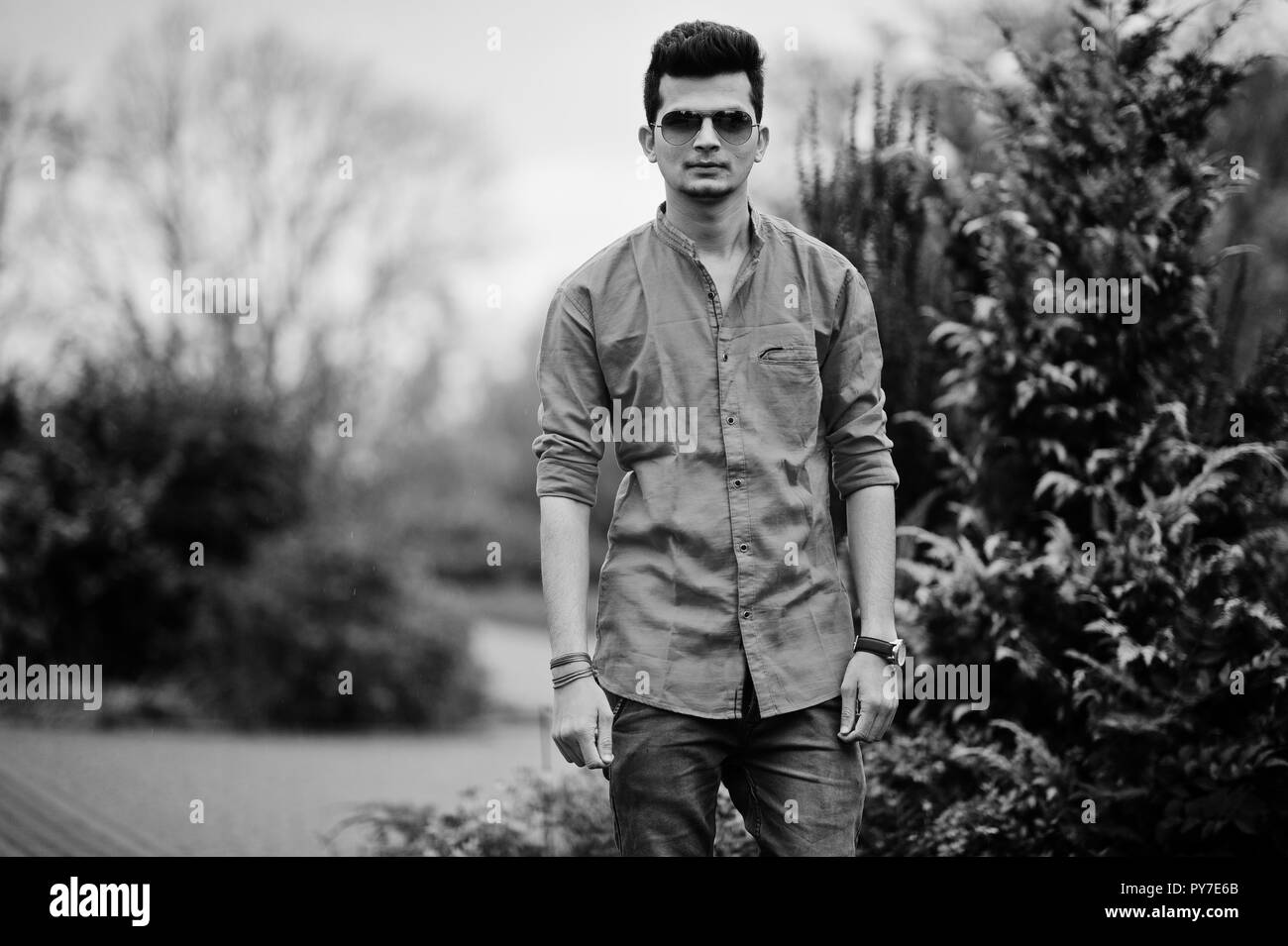 Indian man at red shirt and sunglasses posed outdoor. Black and white photo. Stock Photo
