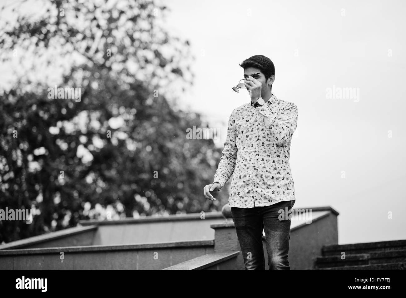 Indian man student at shirt and sunglasses posed outdoor. Black and white photo. Stock Photo