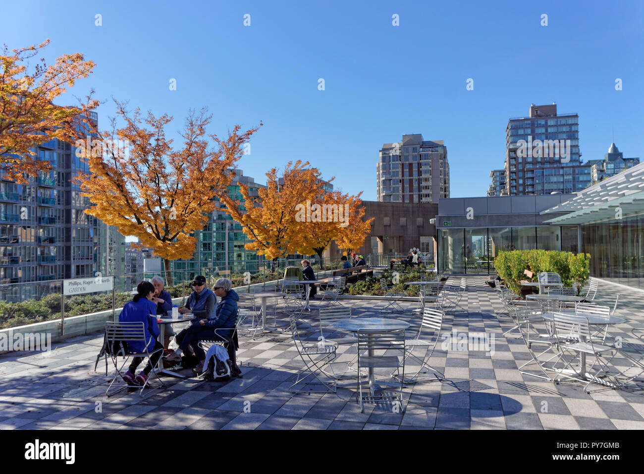 People relaxing and chatting at a table on the Vancouver Public Library rooftop garden that opened on September 29, 2018, Vancouver, BC, Canada Stock Photo