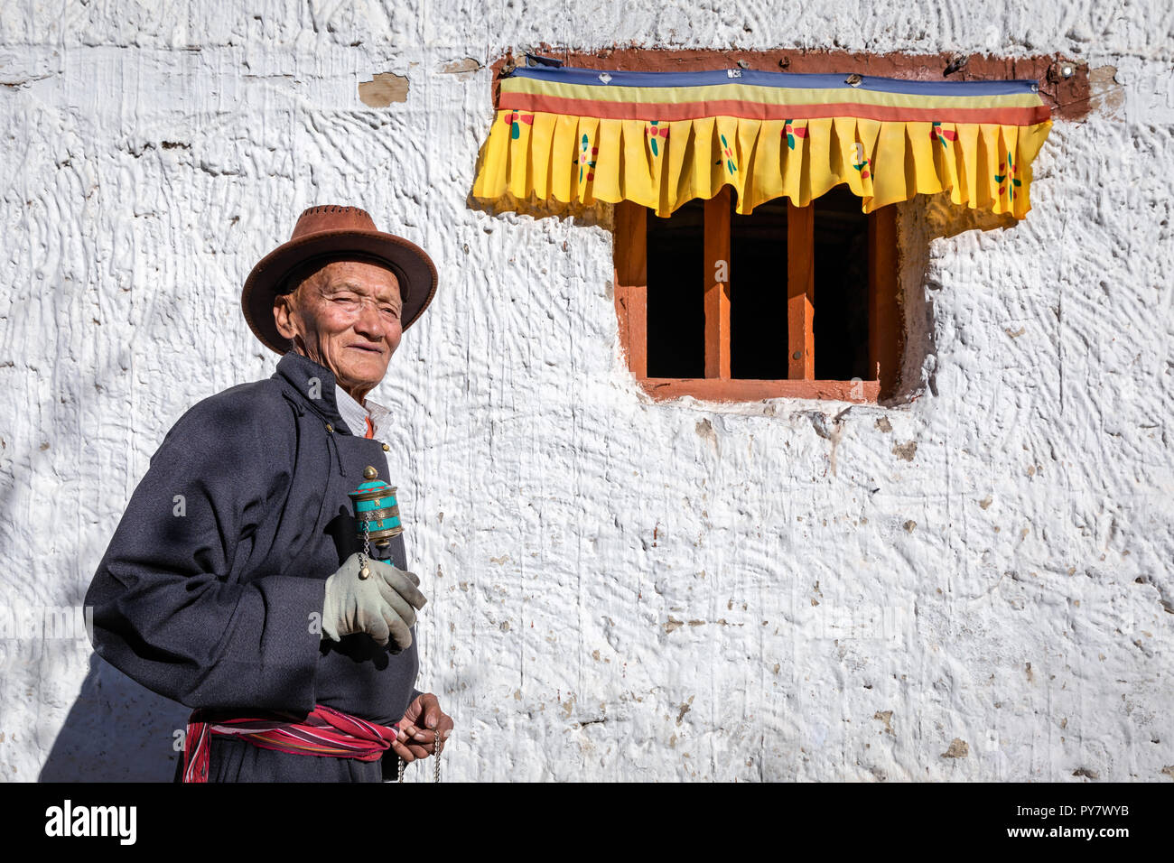 Portrait of an elderly man with a prayer wheel, Spituk Gompa, Leh district, Ladakh, India Stock Photo