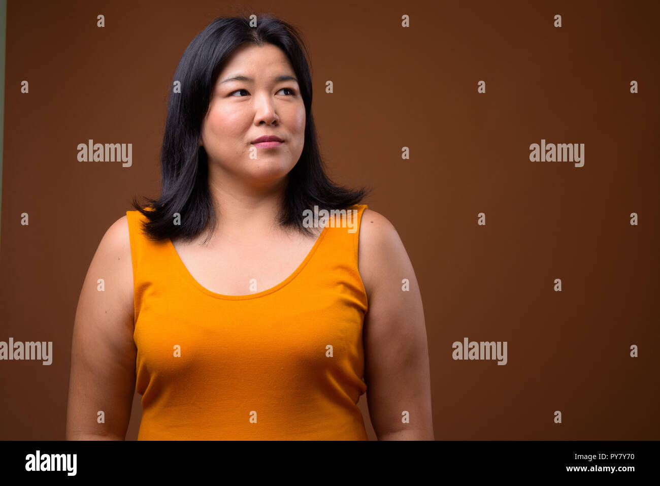 Portrait of beautiful overweight Asian woman thinking Stock Photo