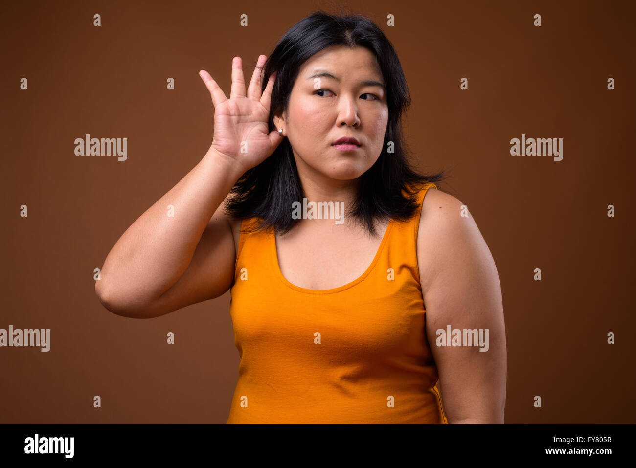 Portrait of beautiful overweight Asian woman listening gossip Stock Photo