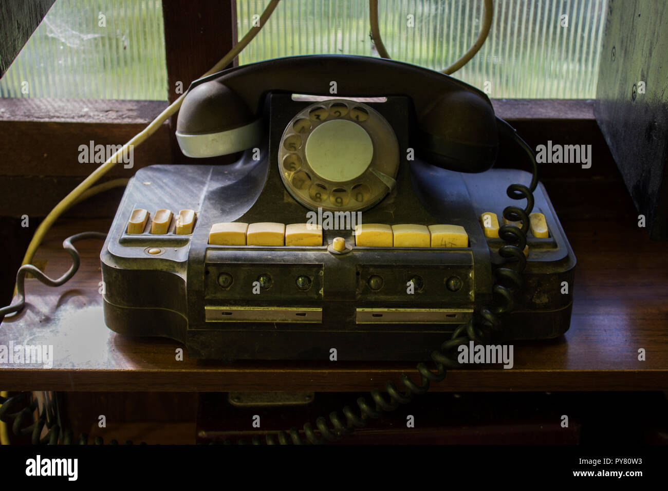 Vintage dusty black rotary telephone on the shelf as part of the collection. Russia, reportage photo Stock Photo
