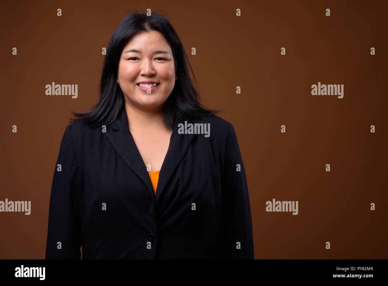 Portrait of beautiful overweight Asian businesswoman smiling Stock Photo