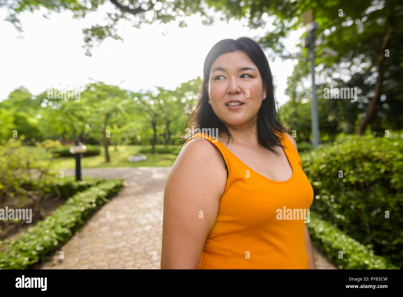 Beautiful overweight Asian woman relaxing at the park Stock Photo