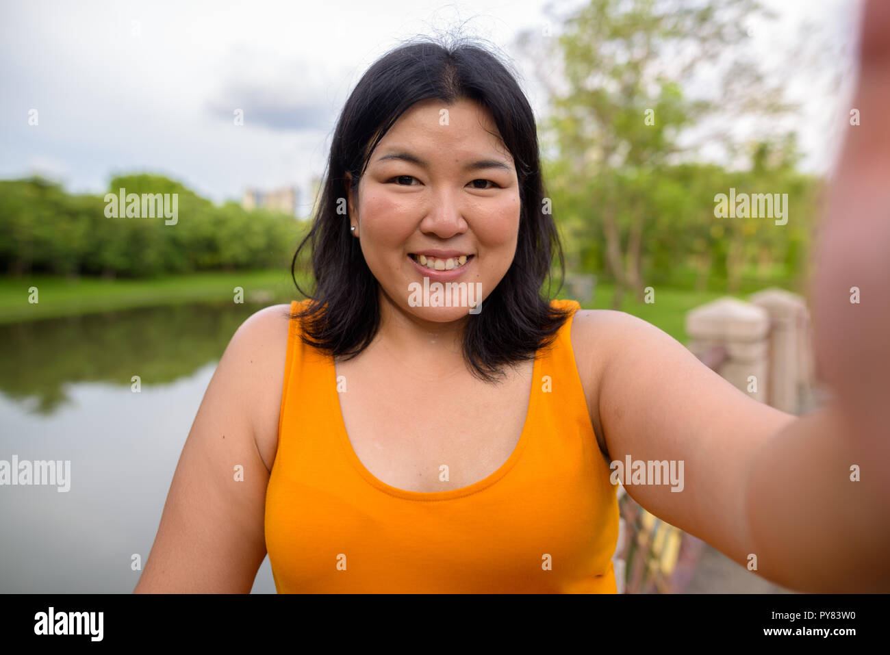 Personal point of view of beautiful overweight woman taking selfie in park Stock Photo
