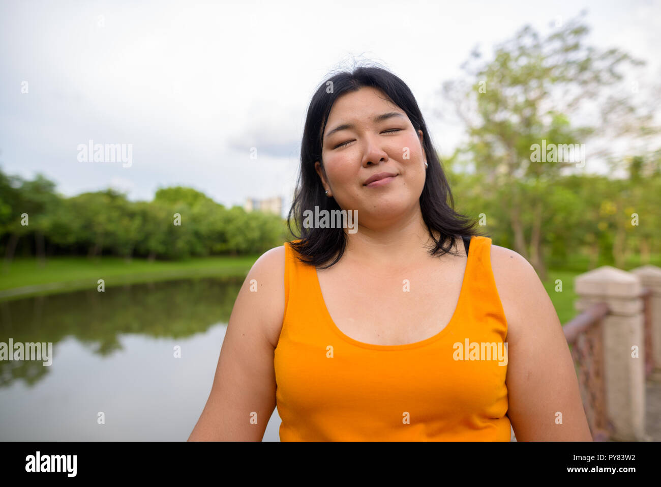 Beautiful woman relaxing with eyes closed in park Stock Photo
