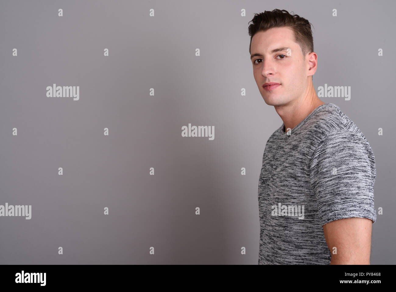 Young handsome man wearing gray shirt against gray background Stock Photo