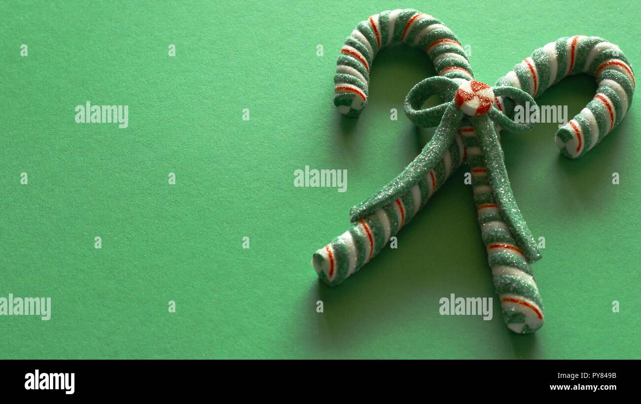 candy canes tied with bow on green background with writing space Stock Photo