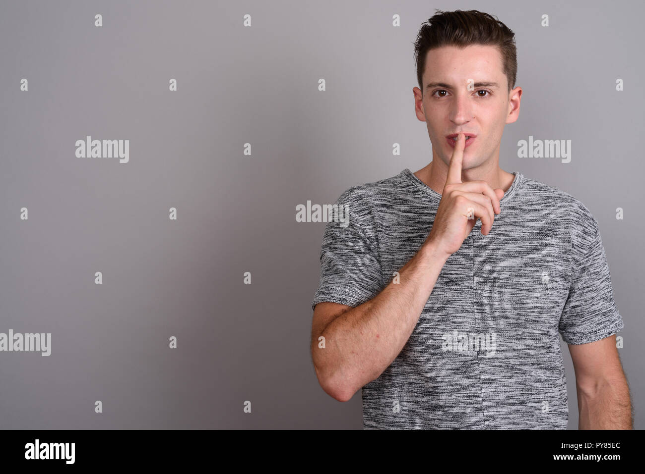 Young handsome man with finger on lips Stock Photo