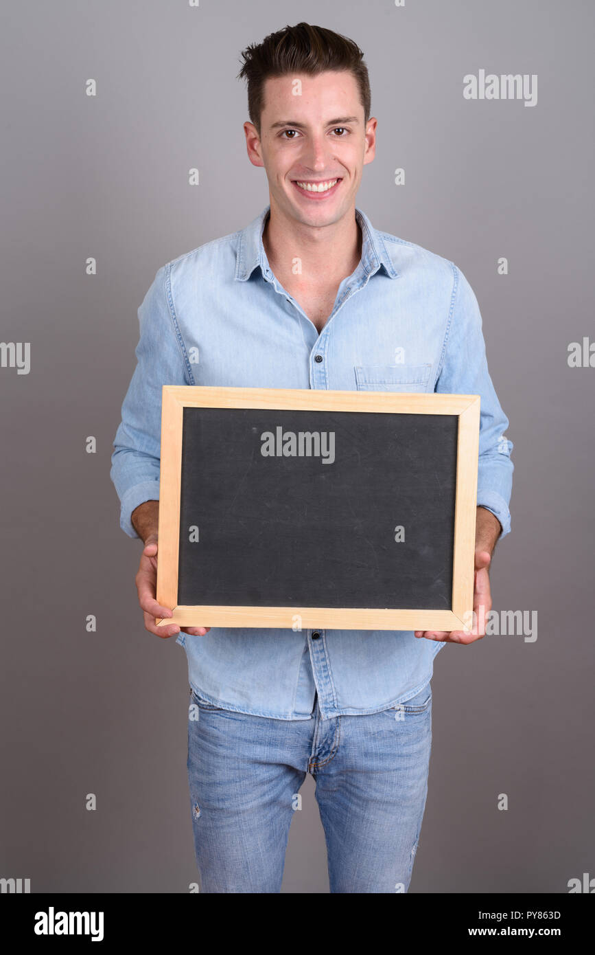 Young happy man holding empty black board with copy space Stock Photo