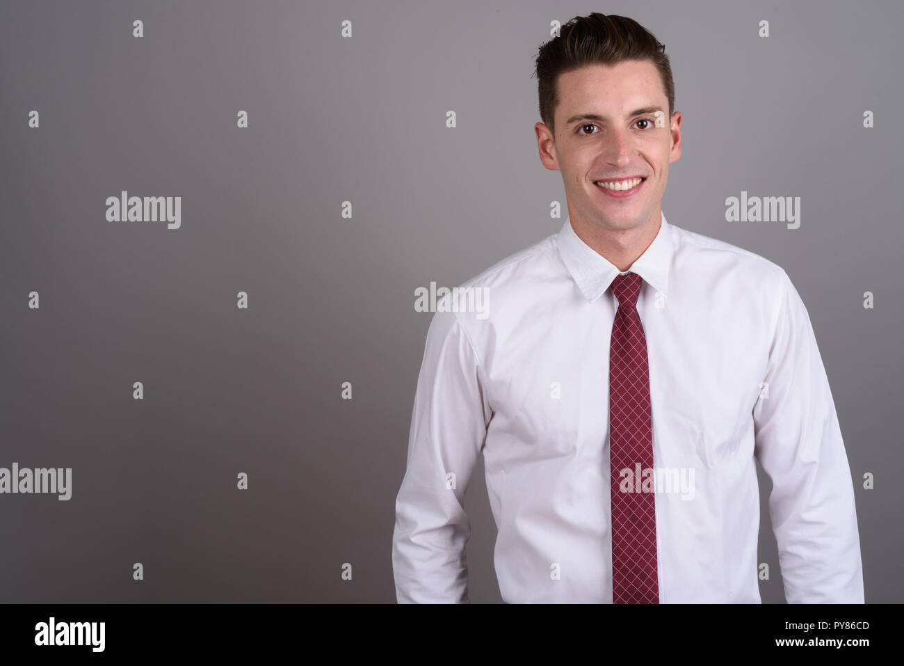 Young handsome businessman smiling and looking at camera Stock Photo