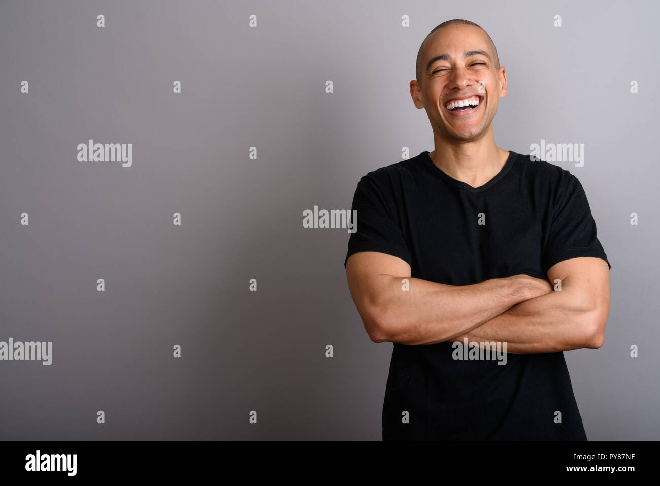 Happy bald man smiling and laughing with arms crossed Stock Photo