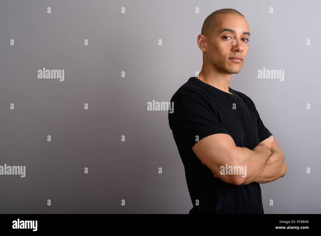 Profile view of handsome bald man with arms crossed Stock Photo