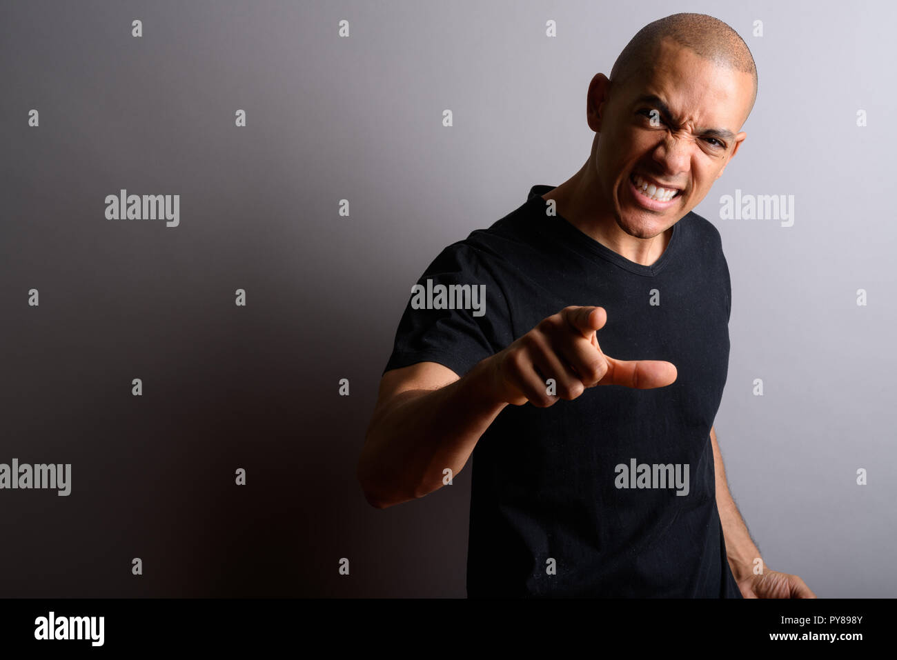Man looking angrily at camera while screaming and pointing finger Stock Photo
