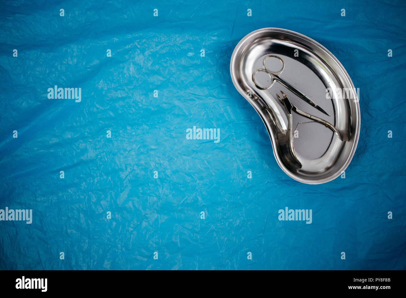 top view of medical instruments in the tray, disposable gloves on blue ...