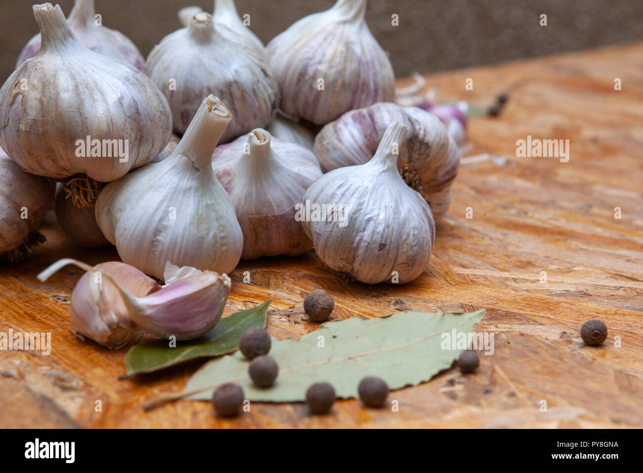 wooden surface with garlic and spices for cooking, closeup Stock Photo
