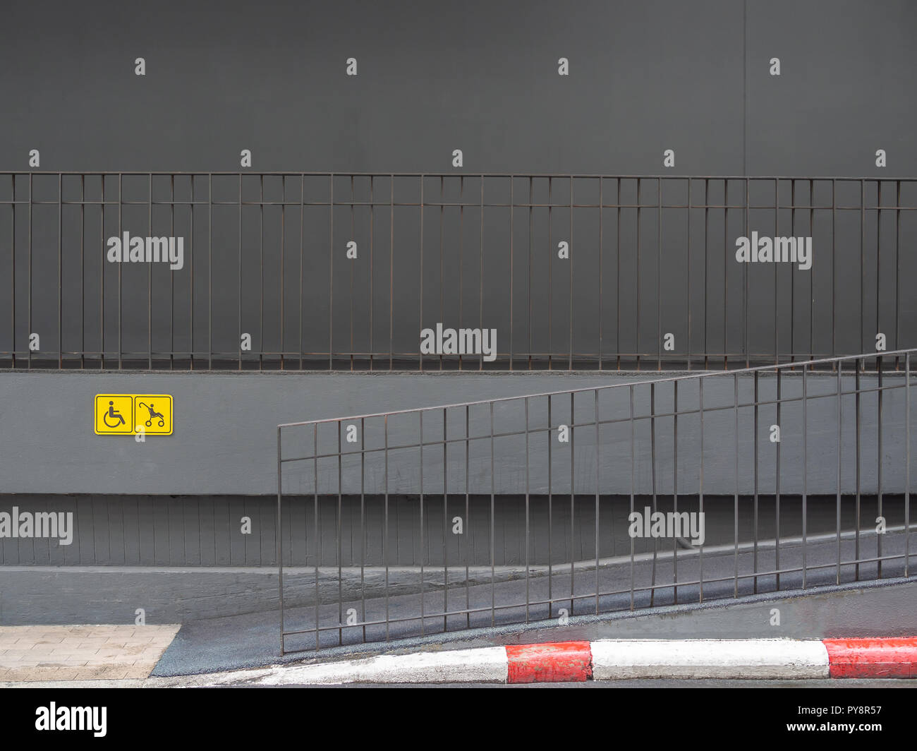 Wheelchair and stroller yellow sign and on the wall and ramp near the ...