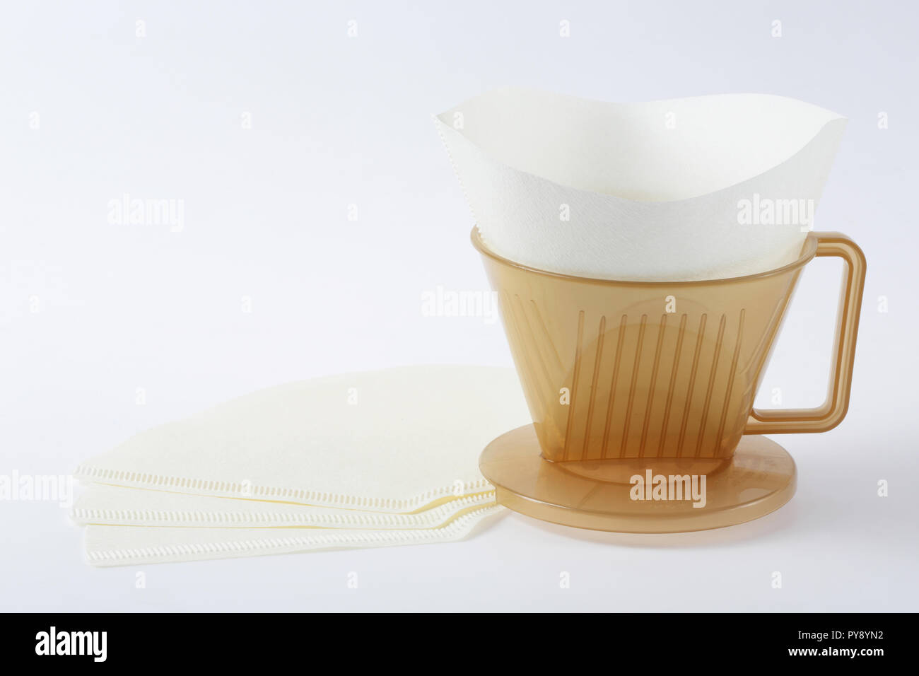 Three holes type coffee dripper with paper filter isolated on white