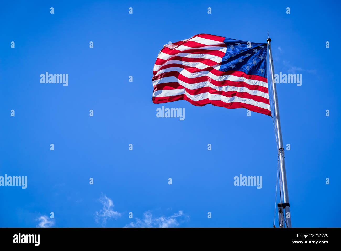 A 15 star American flag flying on a pole on a windy day. Stock Photo