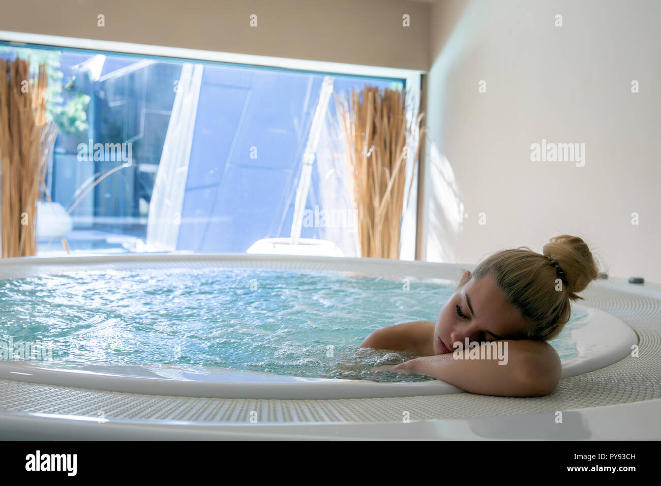Blonde woman resting in jacuzzi Stock Photo Alamy