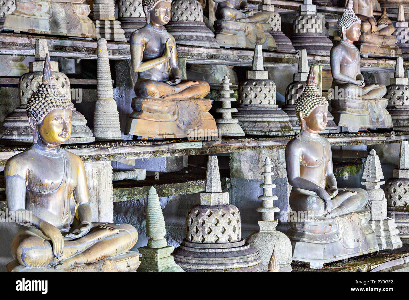 Buddha statues in lotus position and pagodas in the Temple of Gangaramaya in Colombo, Sri Lanka. Stock Photo
