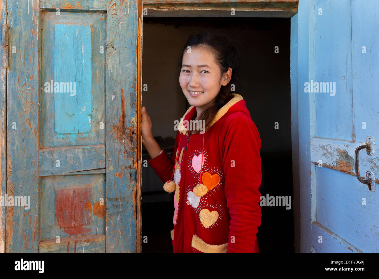 Central asian girl looking through wooden doors, in Nukus, Uzbekistan Stock Photo