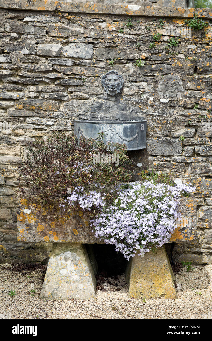 A stone trough in a walled garden UK Stock Photo
