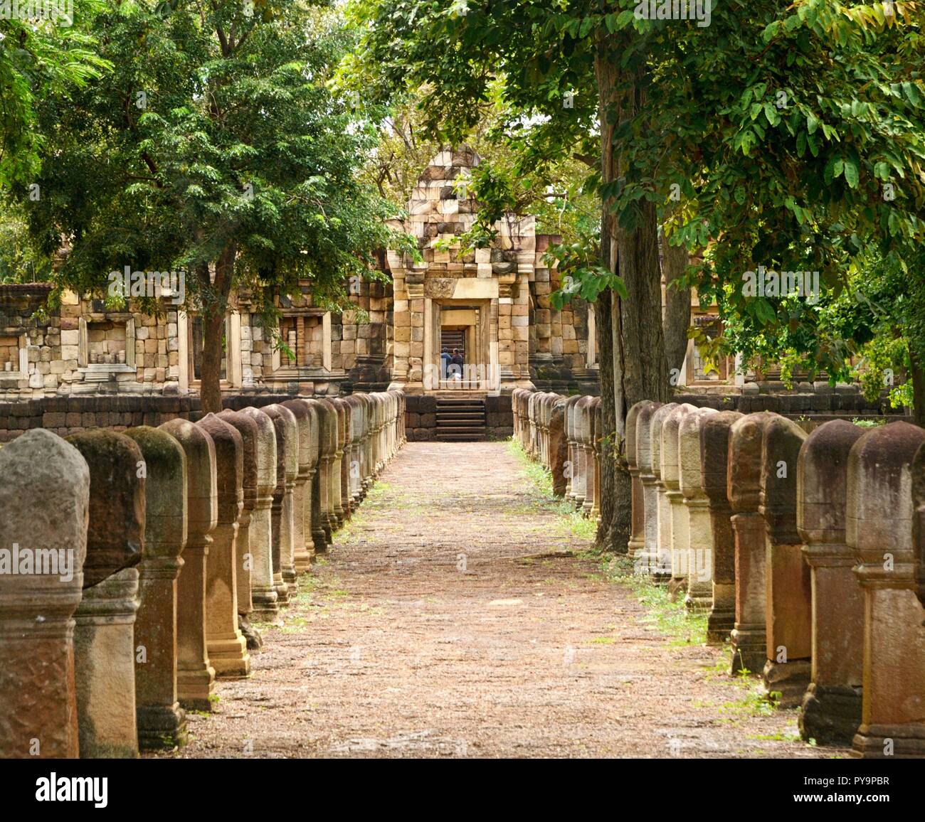 Laterite stone paved walkway with stone posts to the gates of 11th-century ancient Khmer temple Prasat Sdok Kok Thom in Sa Kaeo province of Thailand Stock Photo