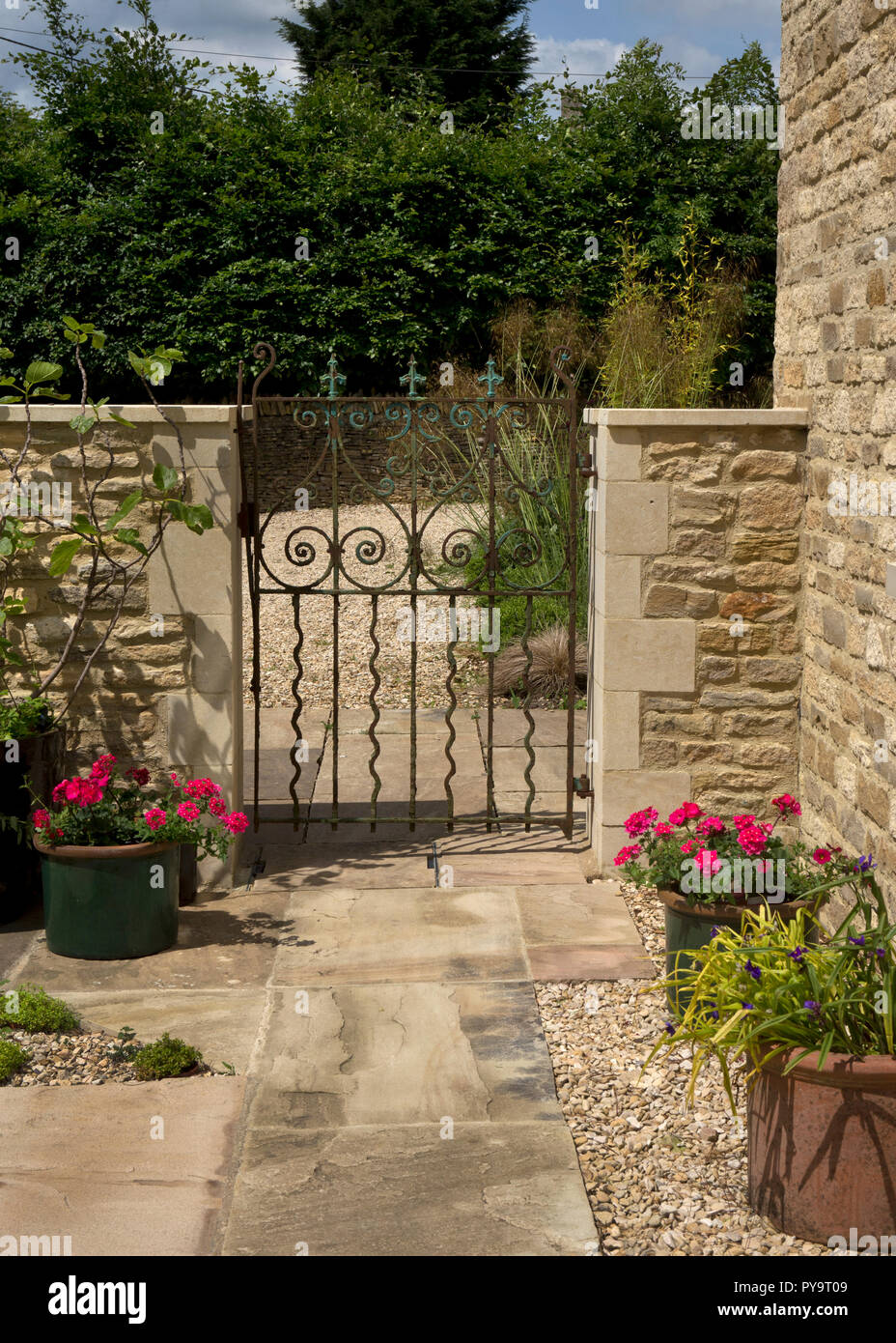 metal gateway with stone wall and pathway leading into English Garden,England,Europe Stock Photo
