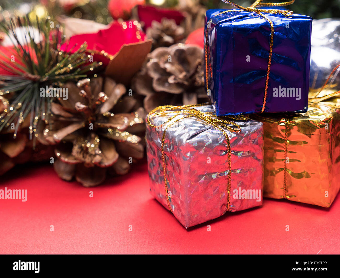 Christmas gift boxes wrapped in different colors under christmas tree