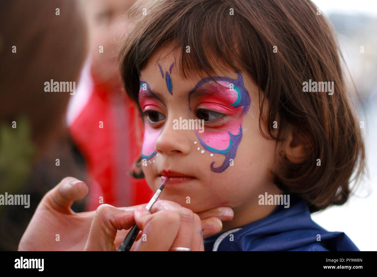 Girl having her face painted as a butterfly Stock Photo