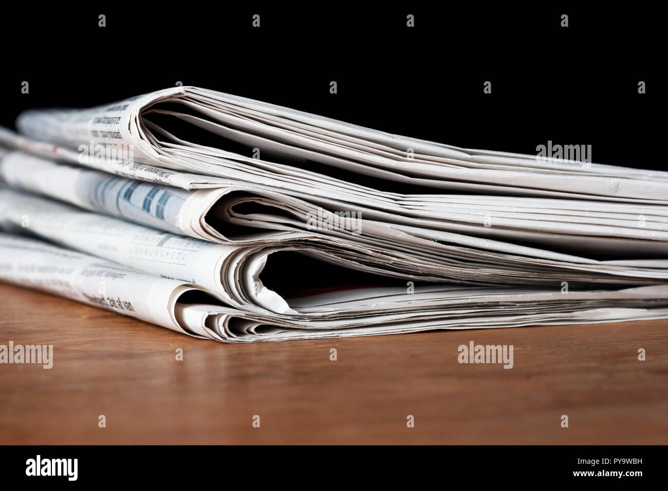 Heap of newspapers on a wooden table Stock Photo