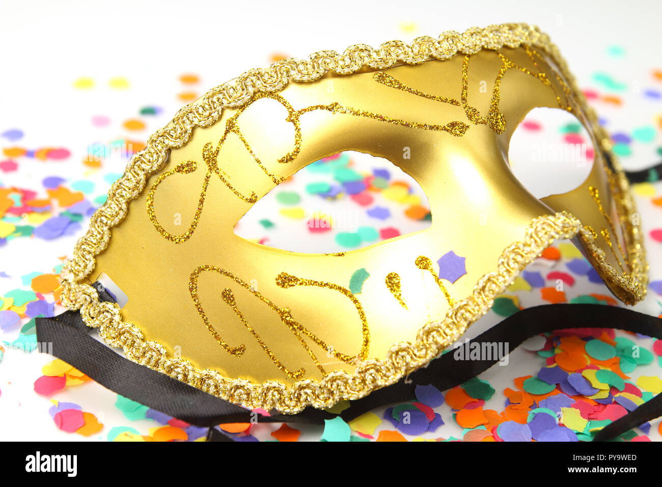 Closeup of a golden carnival mask with confetti Stock Photo
