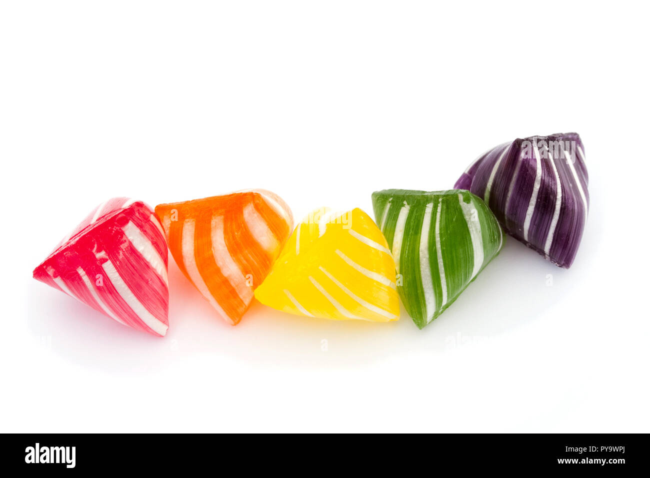 Five rainbow colored sweets in a row: red, orange, yellow, green and purple Stock Photo