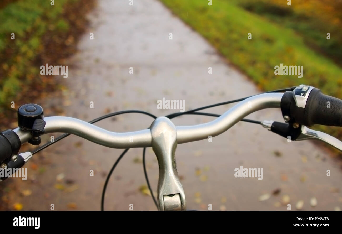 Ready to bike: steering wheel with the bicycle path in the background Stock Photo