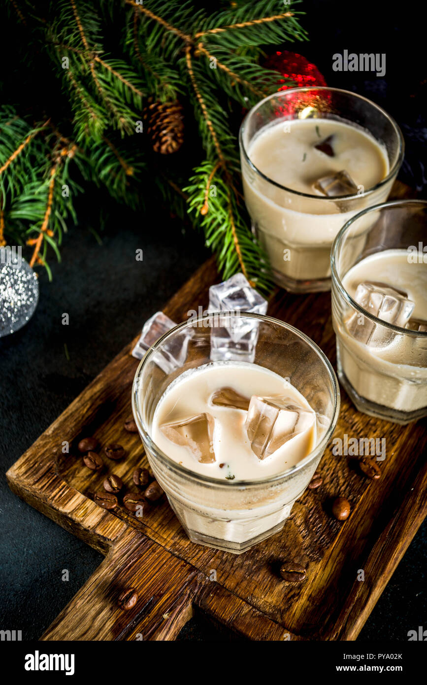 Irish cream cocktail or liqueur, traditional winter christmas drink, dark rusty background with fir tree branches, coffee beans and christmas decorati Stock Photo