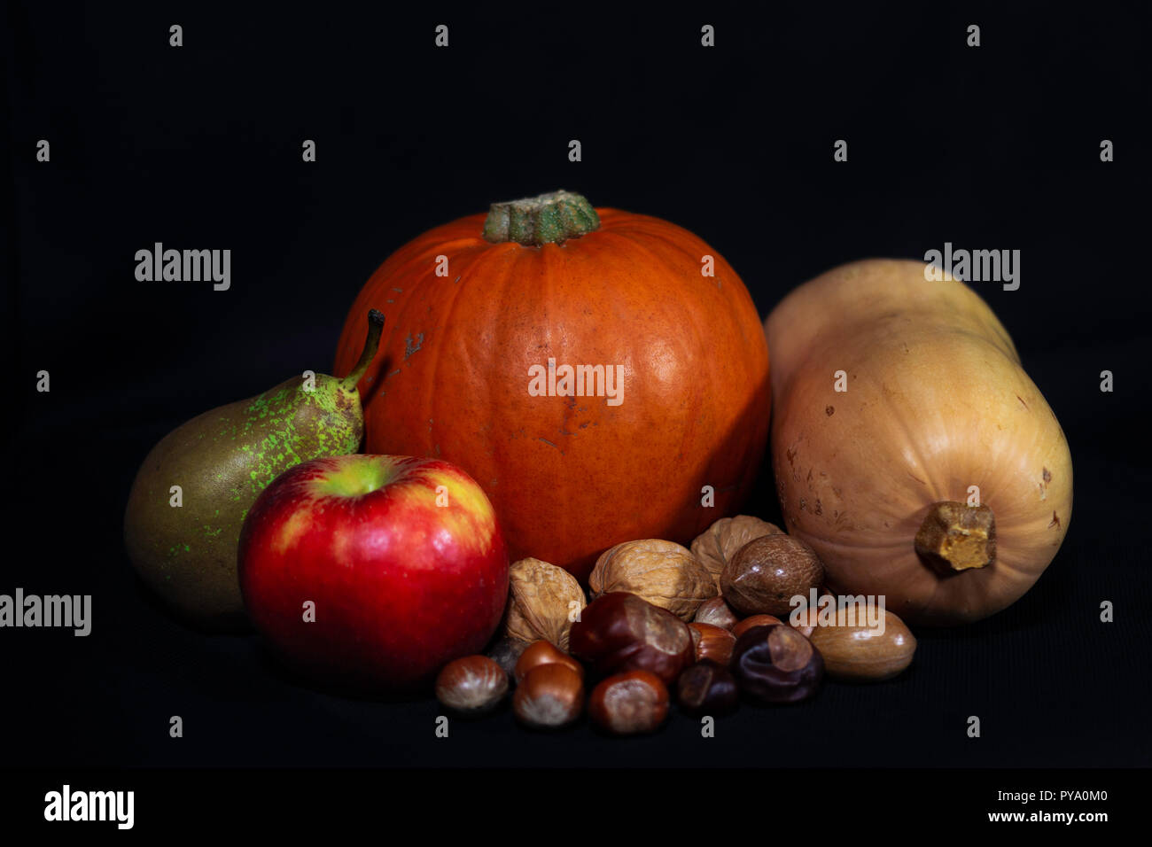 Harvest/Thanks Giving/Samhain/Halloween/Celtic New Year still life. Pumpkin, Squash, apple, pear & pecan nuts, hazelnuts, walnuts, chestnuts/conkers. Stock Photo
