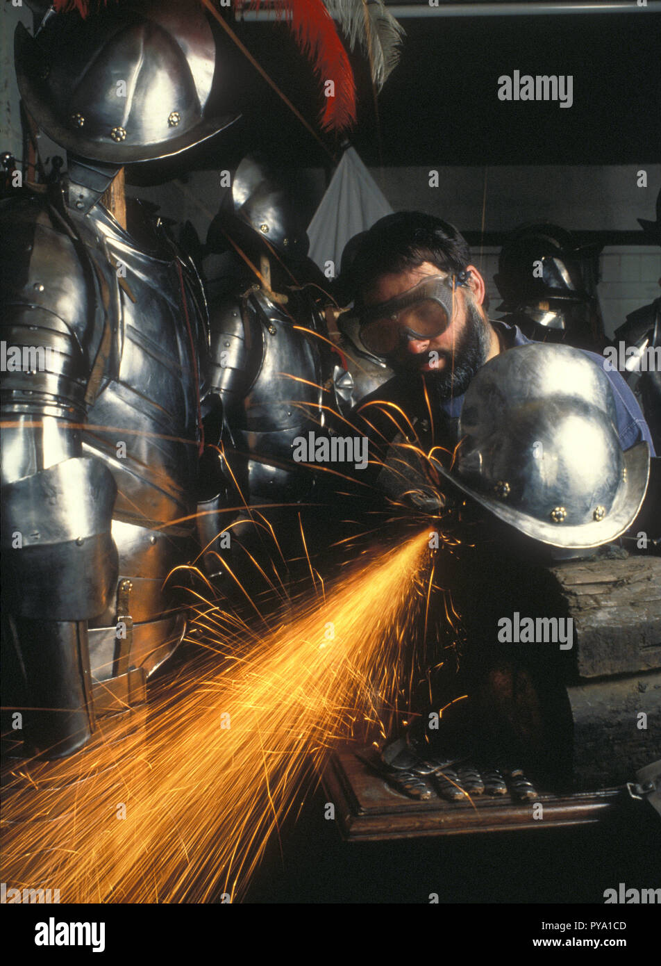 A skilled armourer craftsman puts the finishing touches to a replica suit of armour and morrion, in his workshop in Birmingham, UK Stock Photo