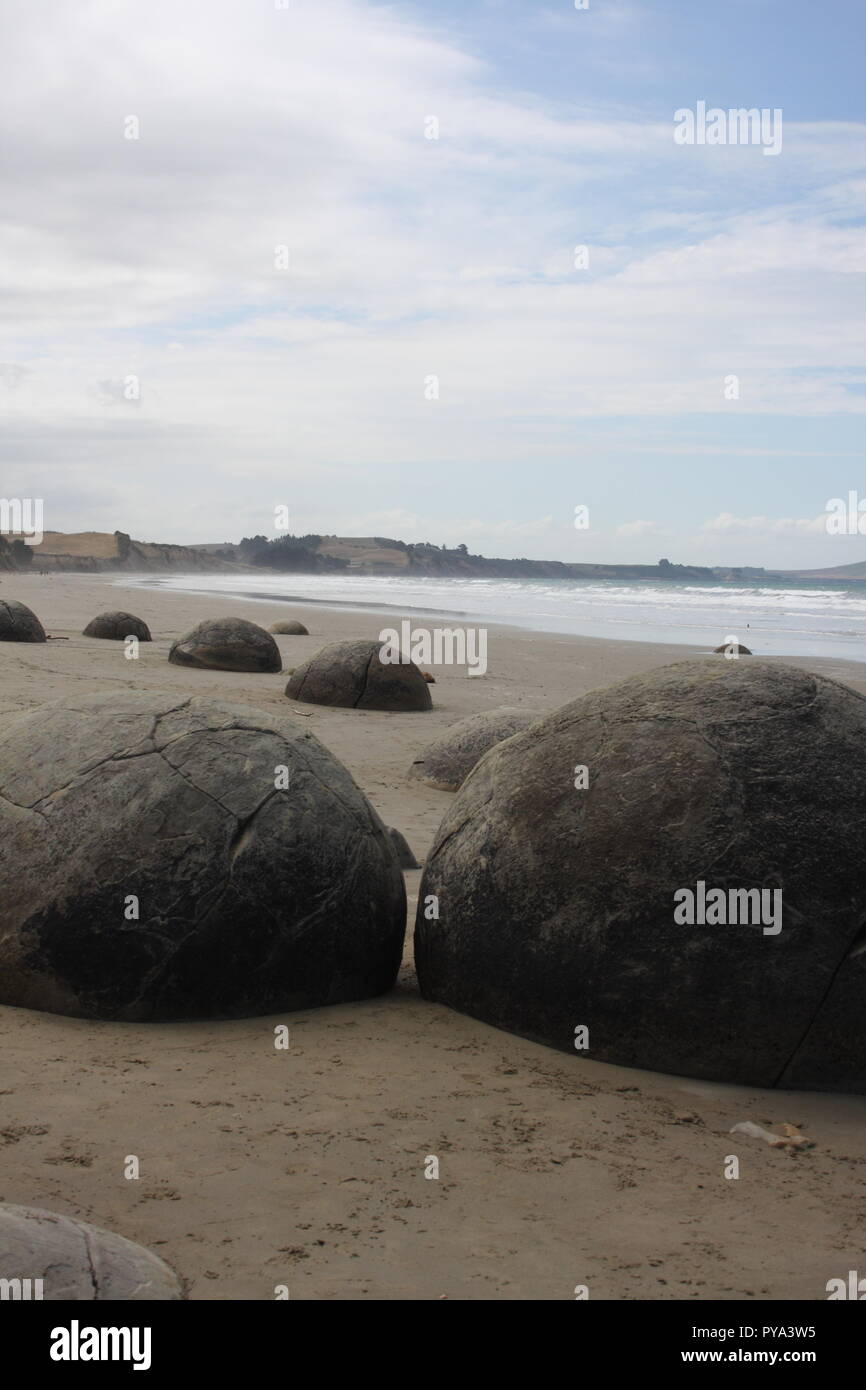 Moeraki boulder beach in New Zealand, this tourism hot spot with this geology feature of round stone rock boulders, is a must for a visitors trip. Stock Photo