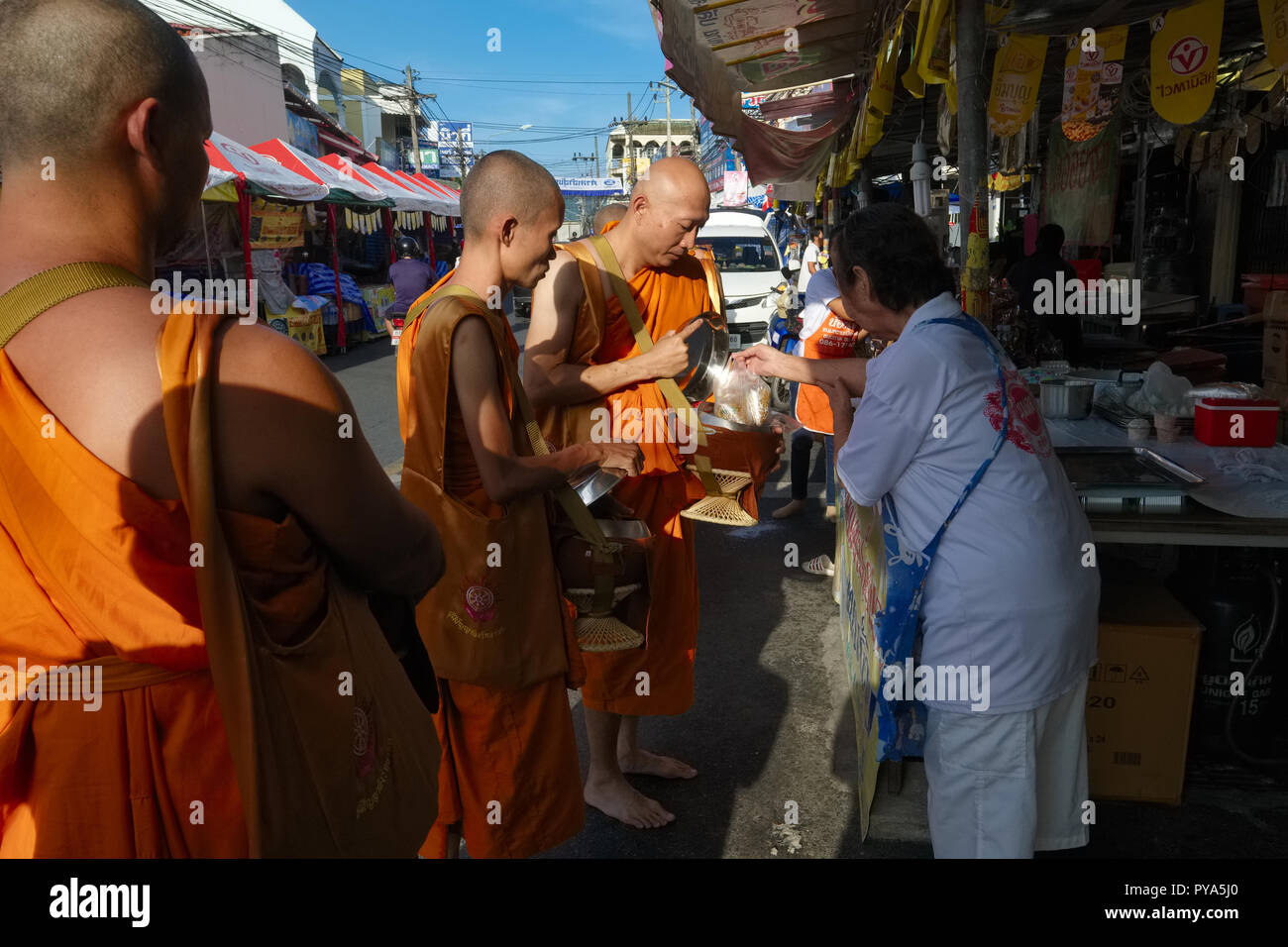 Buddhist Monks residing by the Big Buddha in Phuket, Thailand, on their early morning alms round in a market in Ranong Rd., Phuket Town Stock Photo