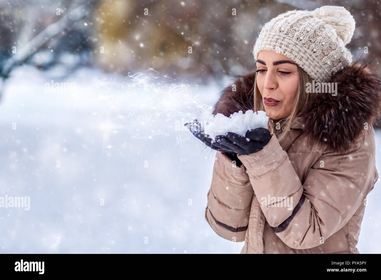 beautiful young woman blowing magic snow Marry Christmas Stock Photo
