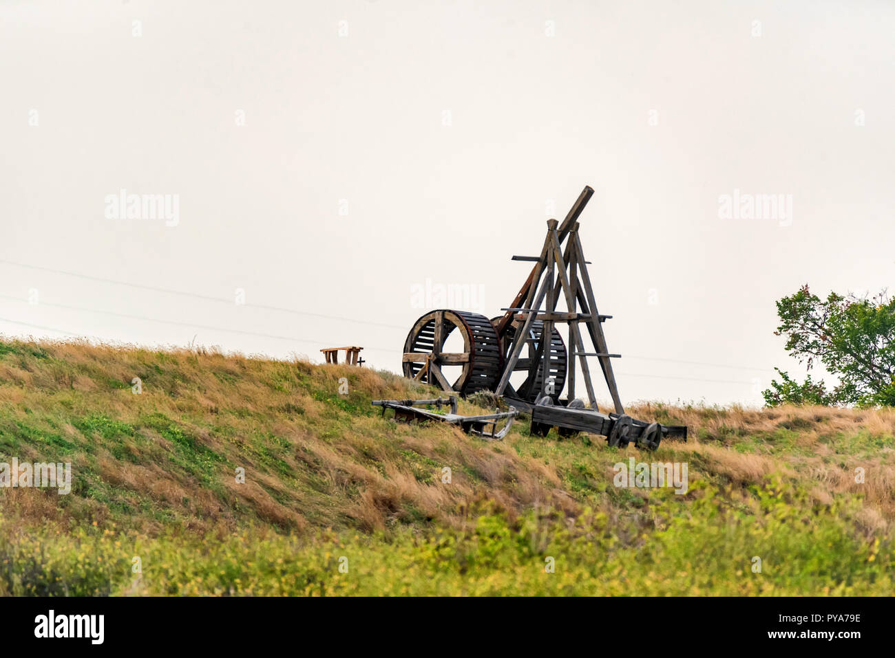 Old wooden catapult against grey sky background Stock Photo