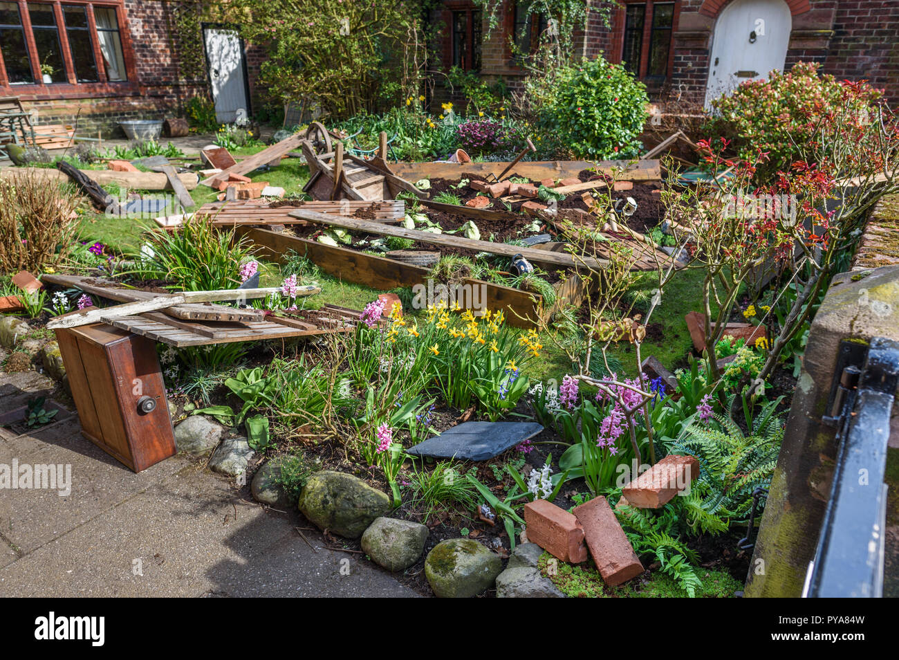 Props and debris litter a cottage garden for  the new BBC drama 'War Of The Worlds' by HG Wells,filmed at Great Budworth village, Cheshire, April 2018 Stock Photo