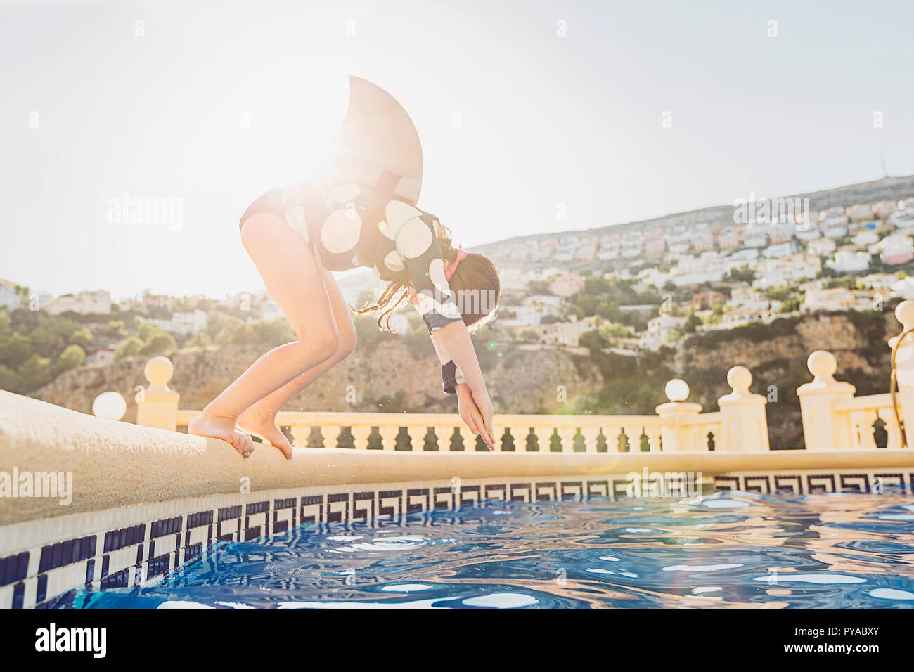 Young Girl diving into pool Stock Photo