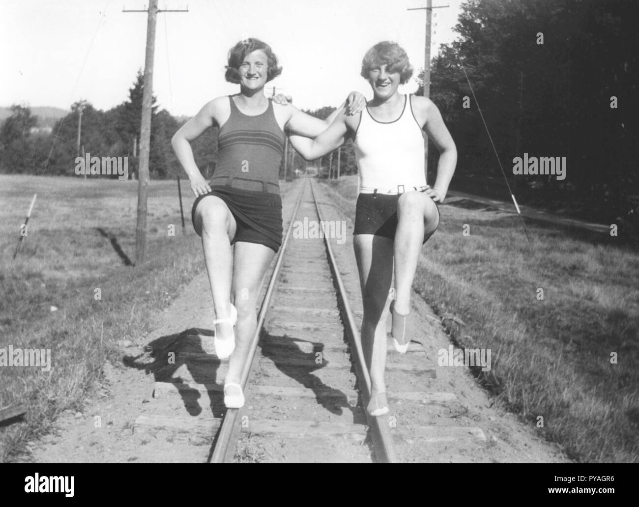 Fun in the 1930s. Two young women in bathing suits are balancing on the