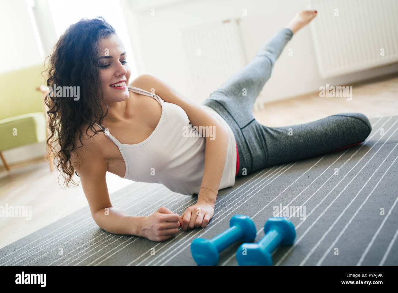 Young attractive sportswoman doing exercises at home Stock Photo