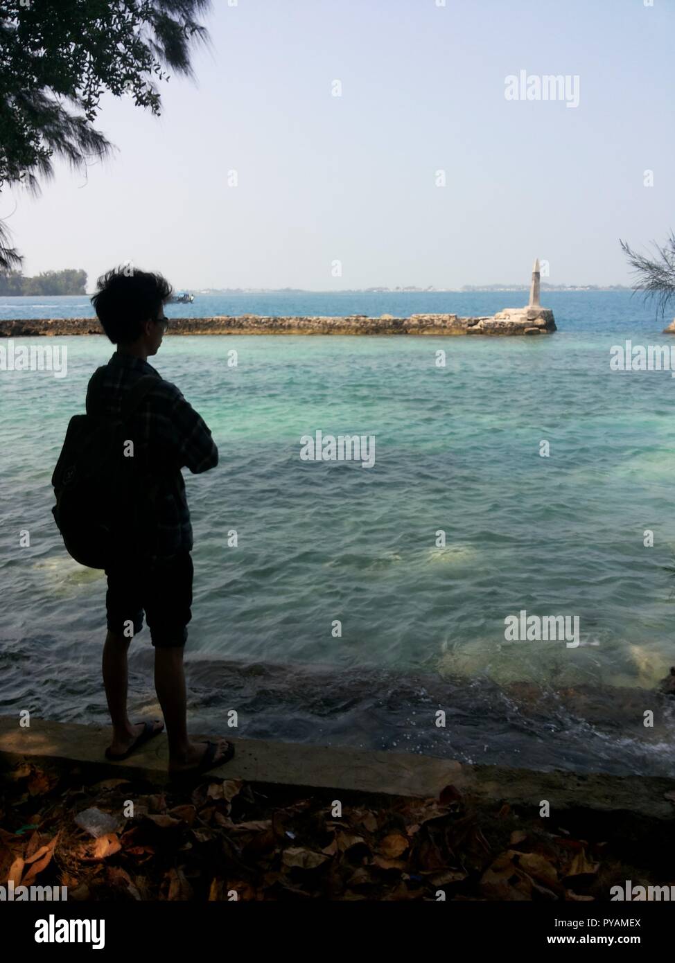 A man silhoutte while looking to the Bulat island's beach Stock Photo