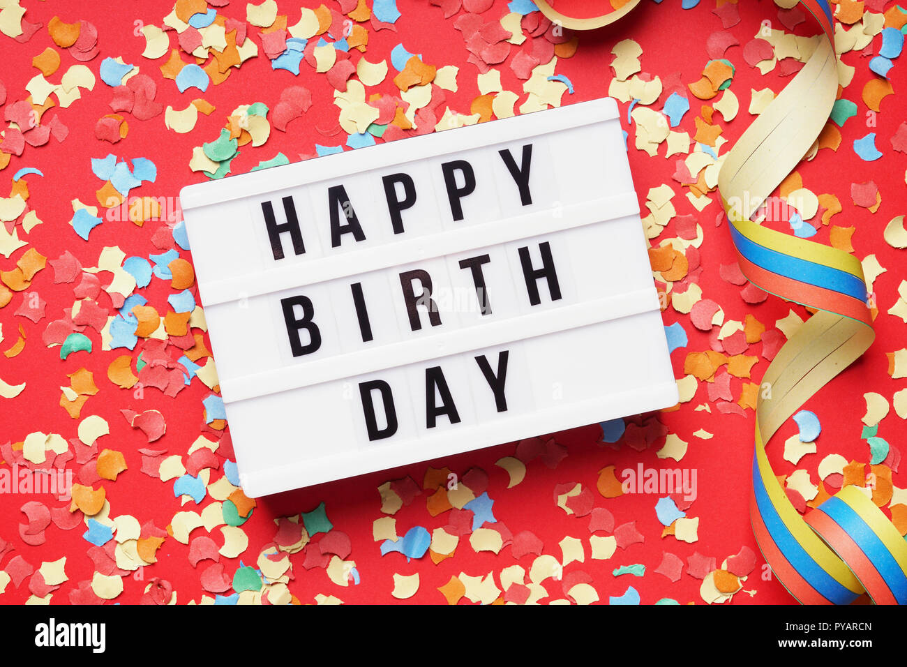 happy birthday flat lay design with lightbox sign and confetti Stock Photo
