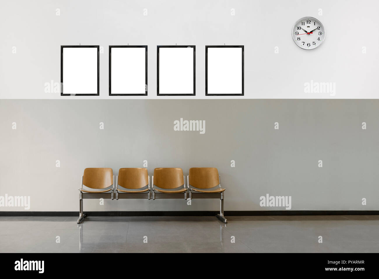 empty waiting room with chairs, clock and hanging frames with copy space. Stock Photo